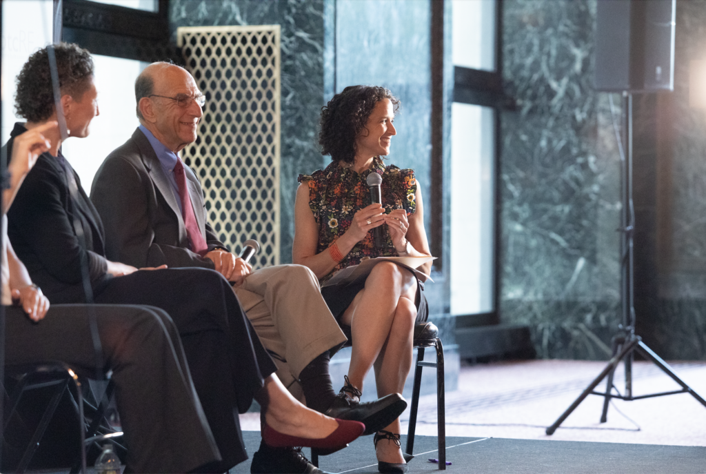 Leah Rothstein, Richard Rothstein, and Marisa Novara sit in a row.