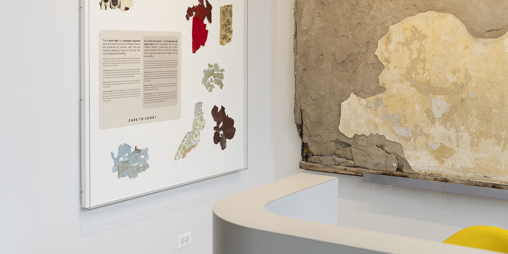 A museum display case with paint chips and a fragment of a wall