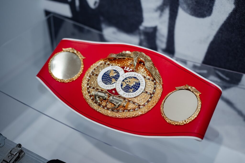 A championship boxing belt in a display case