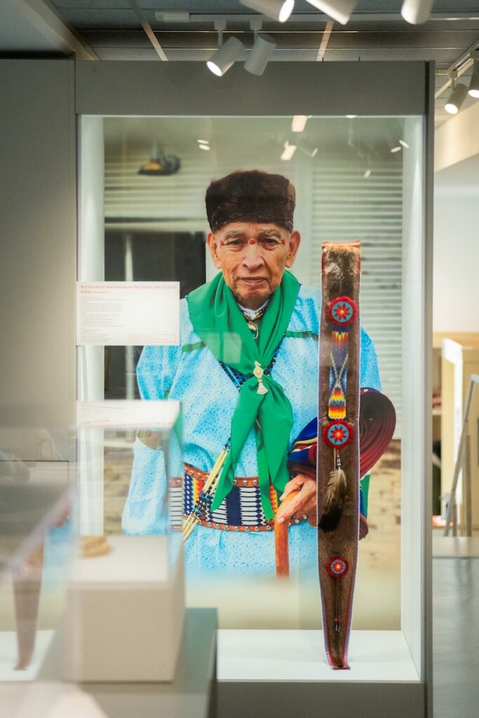 A tall case displaying Osage regalia