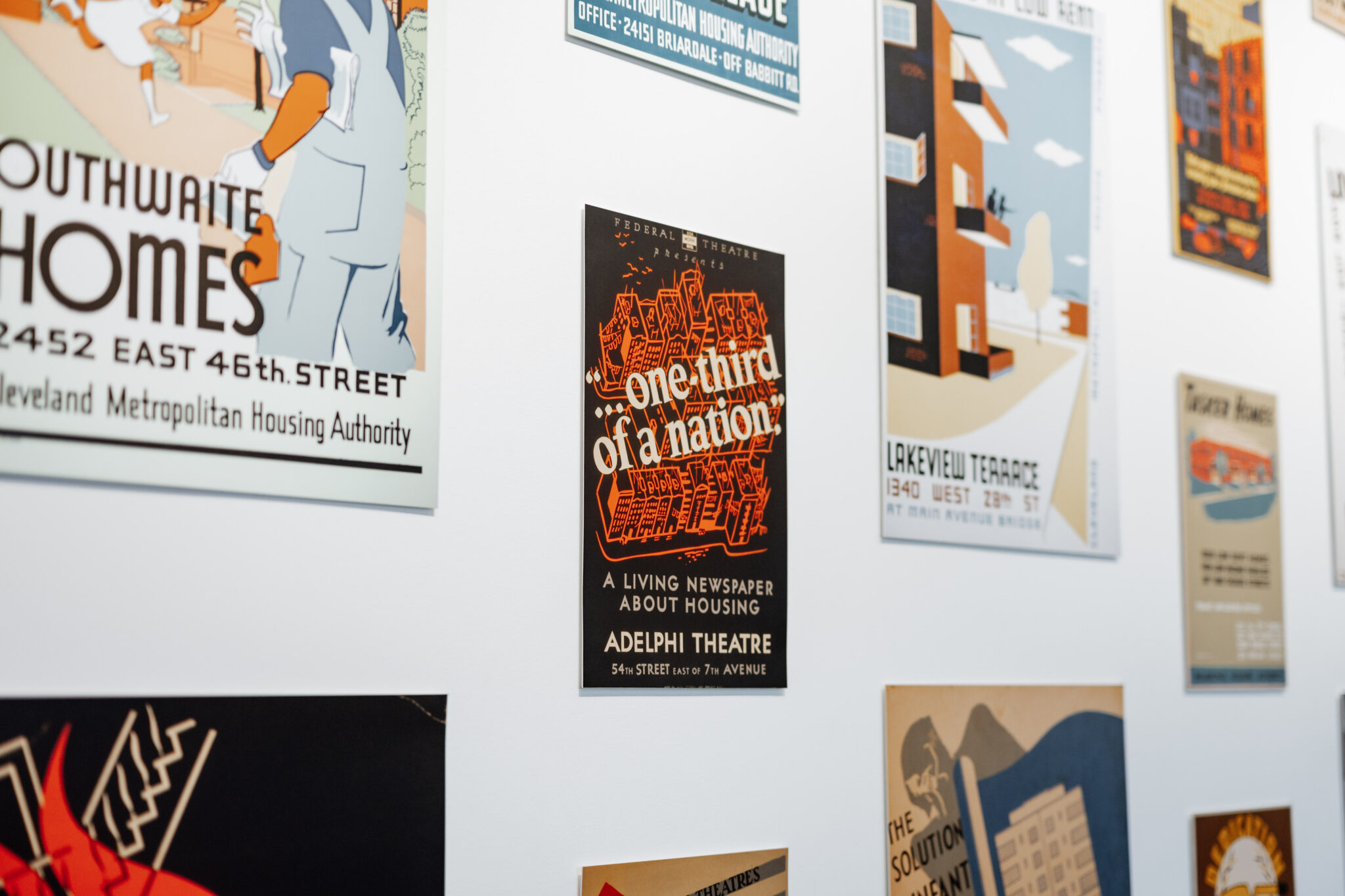 Detail of WPA era posters hung salon style on a gallery wall