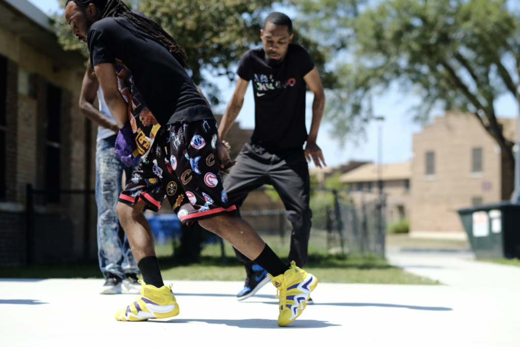 Still from _Footwork Saved My Life Film_, courtesy of ShaDawn Battle and Kameron Davis_Three Dancers outside Altgeld Gardens public housing.