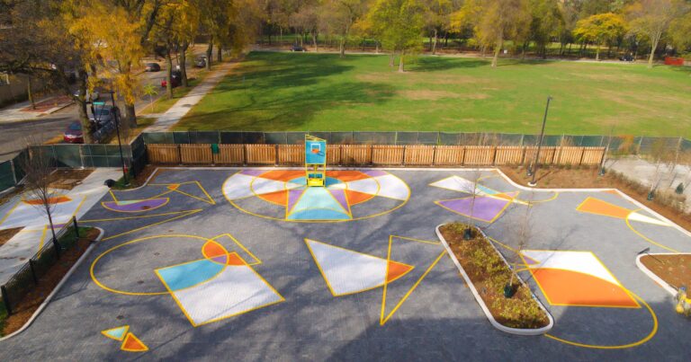 Painted overlapping circles and triangles form a playful mural on a parking lot surface