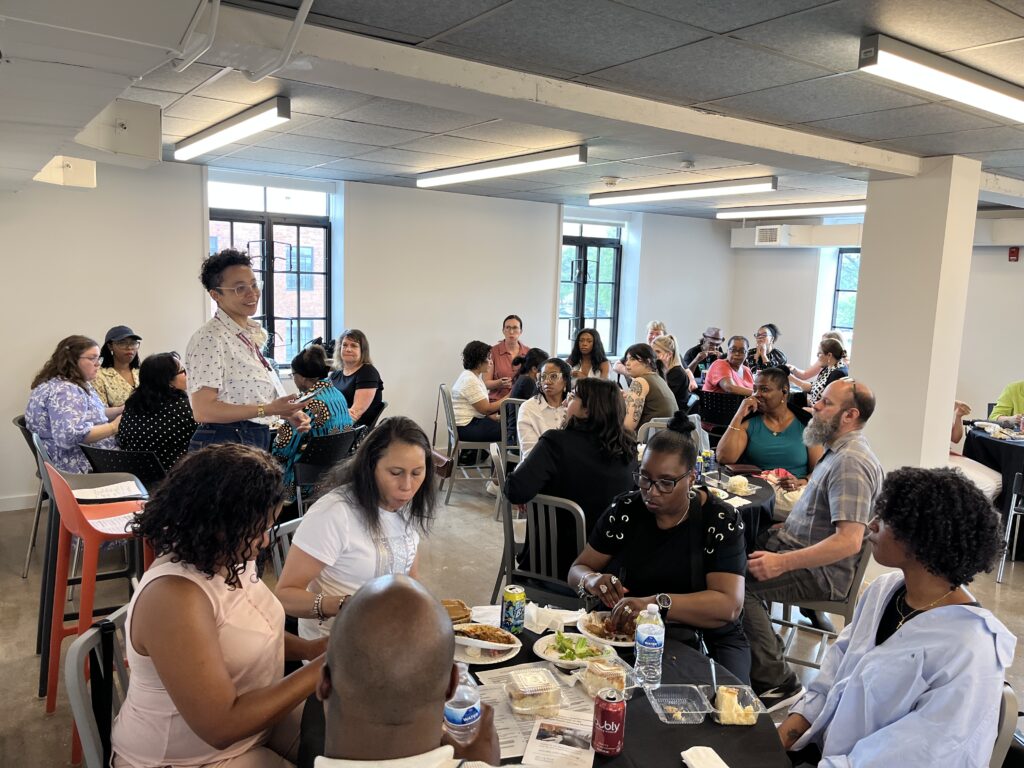 People eating together at round tables in an event space
