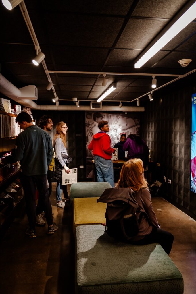 People browsing records in a narrow room
