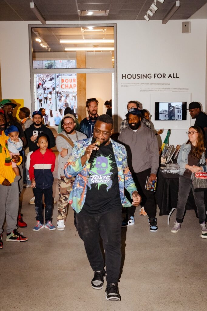 A rapper walking and performing surrounded by the audience