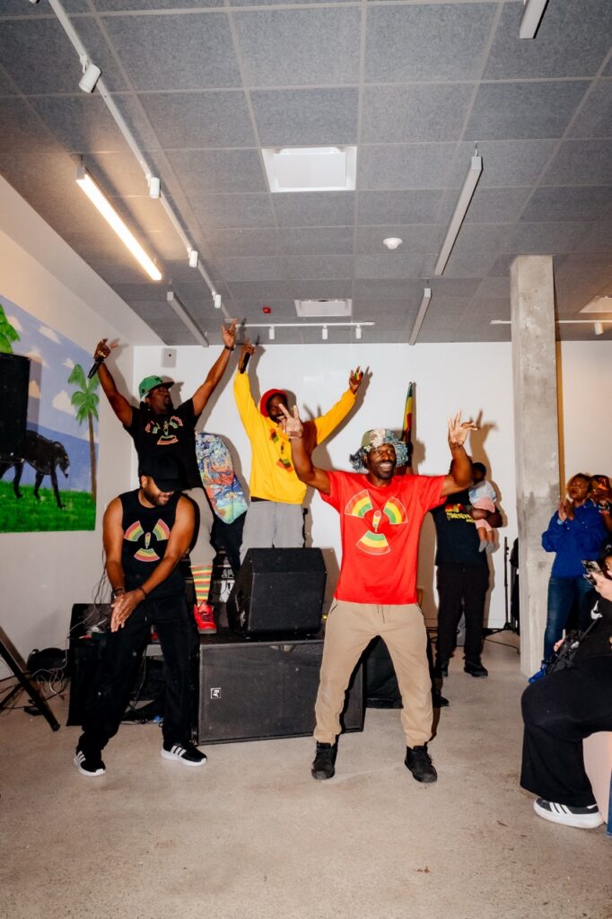 A hip-hop group raises their hands during a performance