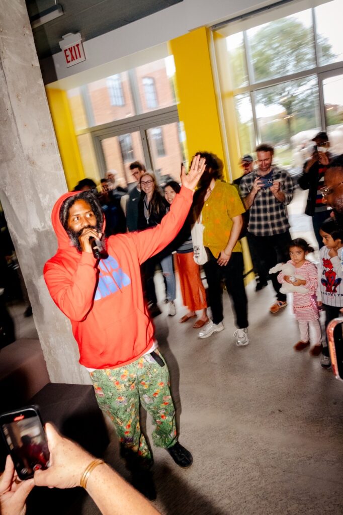 A man with a beard and a microphone welcomes people to an event