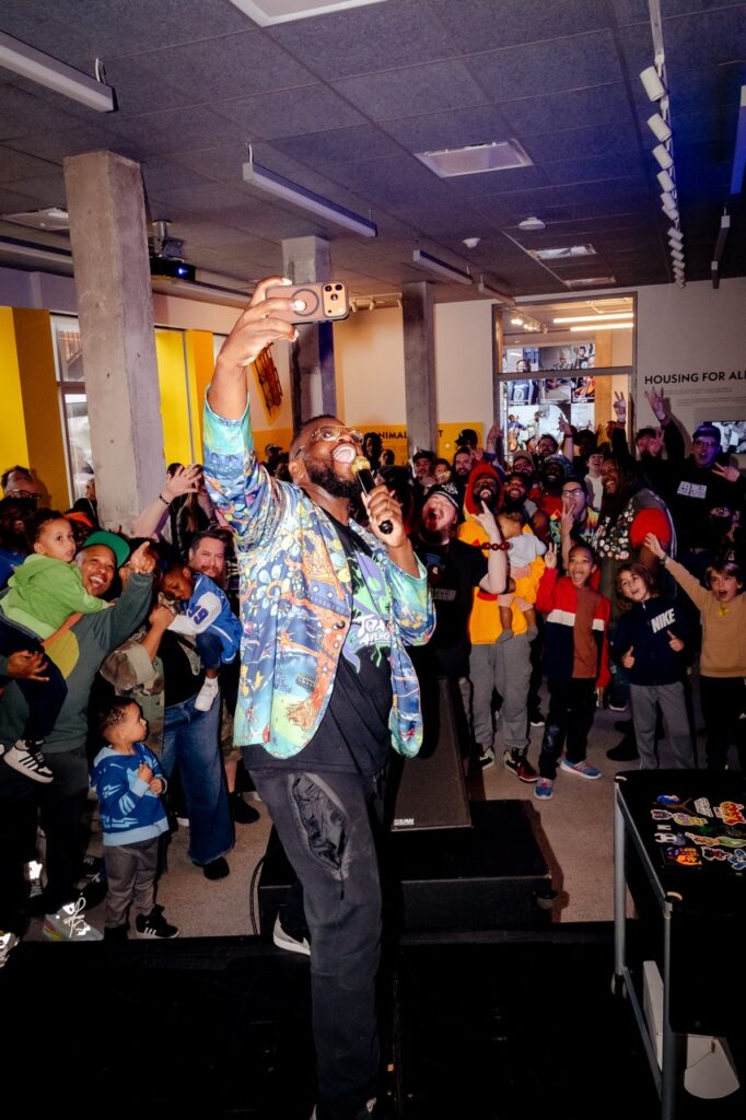 A performer takes a selfie with the audience behind him