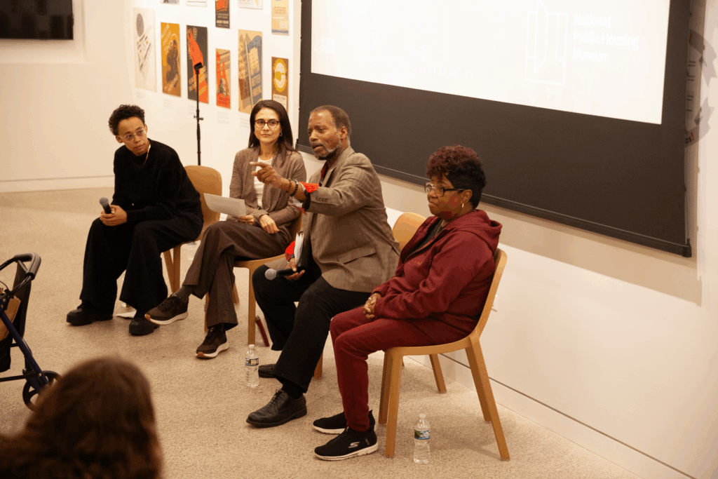A panel of speakers in front of a projector screen