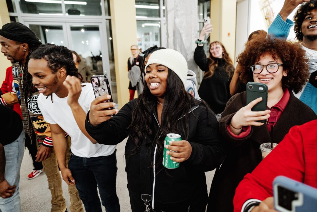 An audience member films a dance cypher