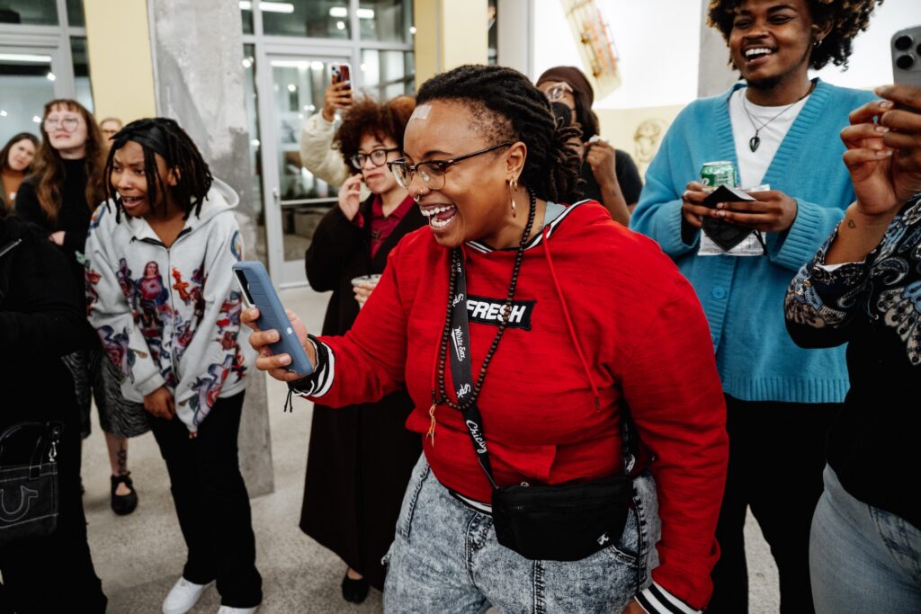 An audience member films a dance cypher