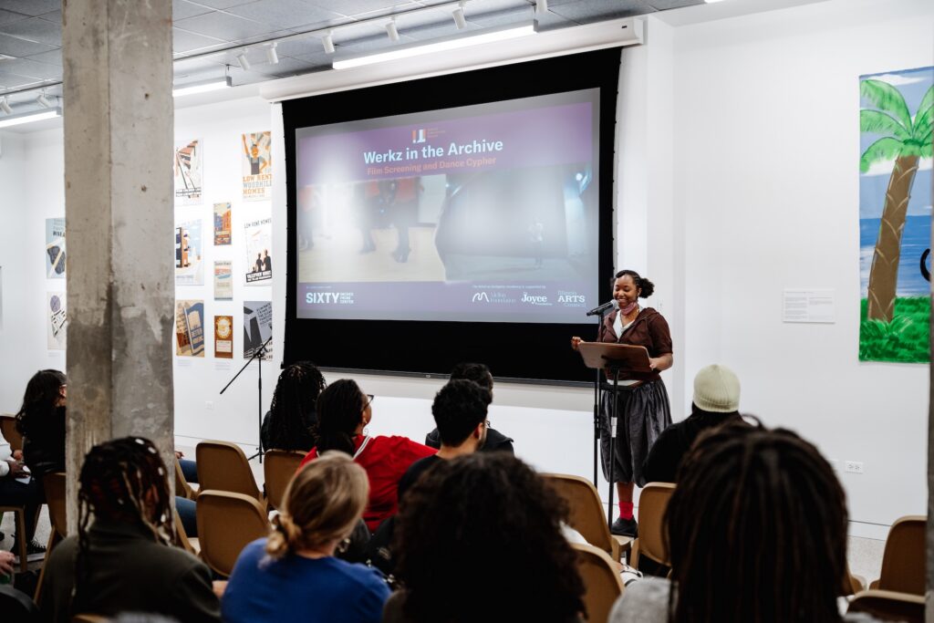 At the podium, with a slide about the event Werkz in the Archive