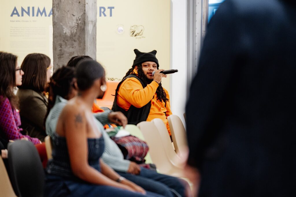 A person seated with a microphone talking at an event
