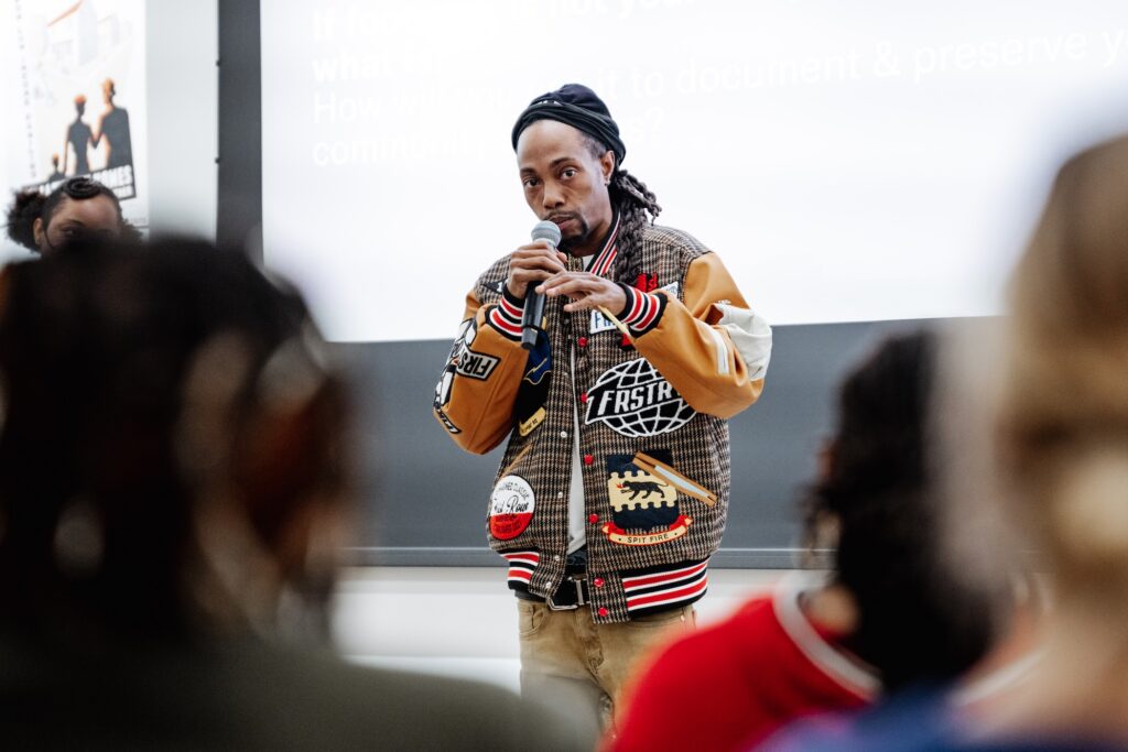 A person with a microphone talks in front of an audience