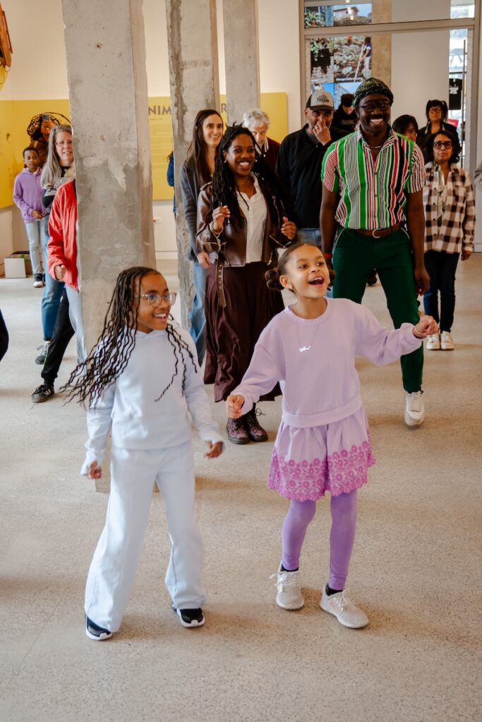 Kids and adults learning a dance