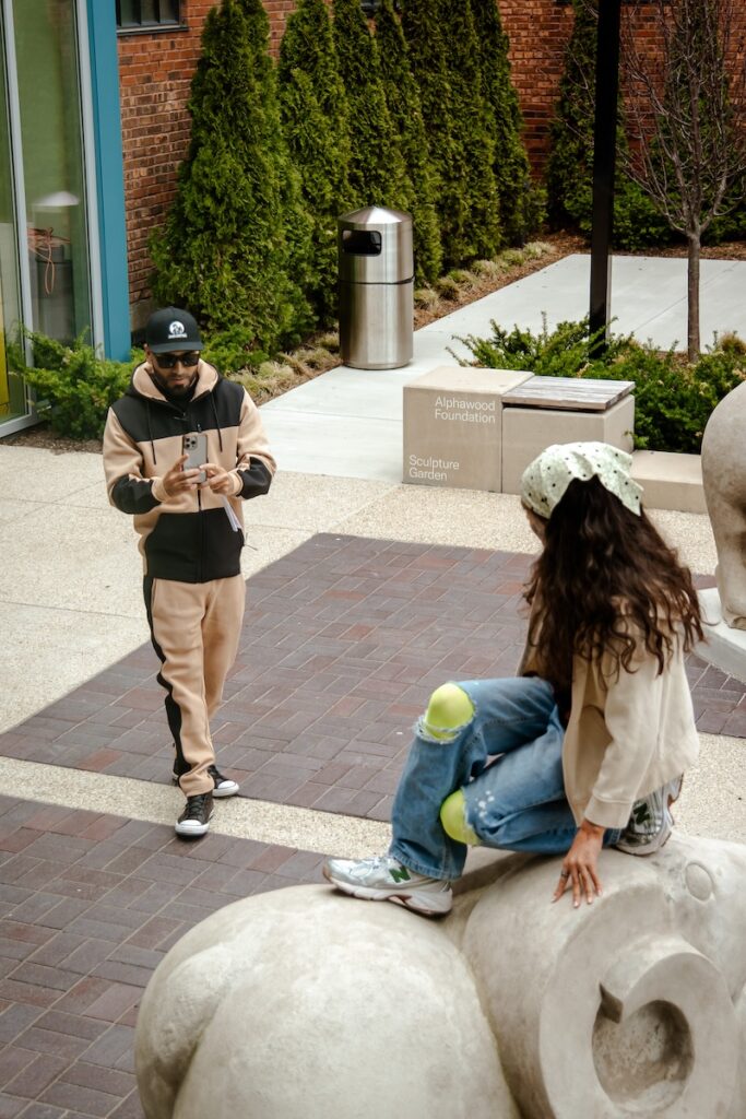 A kid on top of a animal sculpture posing for a photo