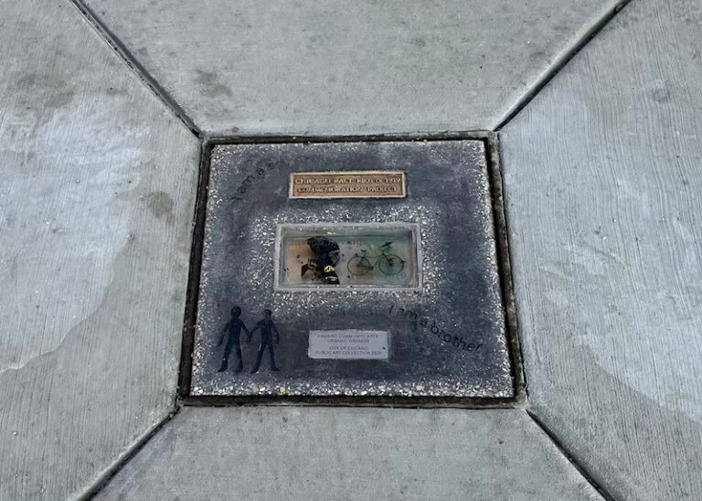 A glass brick and brass plaque embedded in concrete