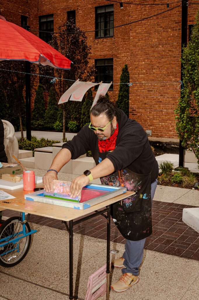 William Estrada with a mobile screen printing cart outside the National Public Housing Museum