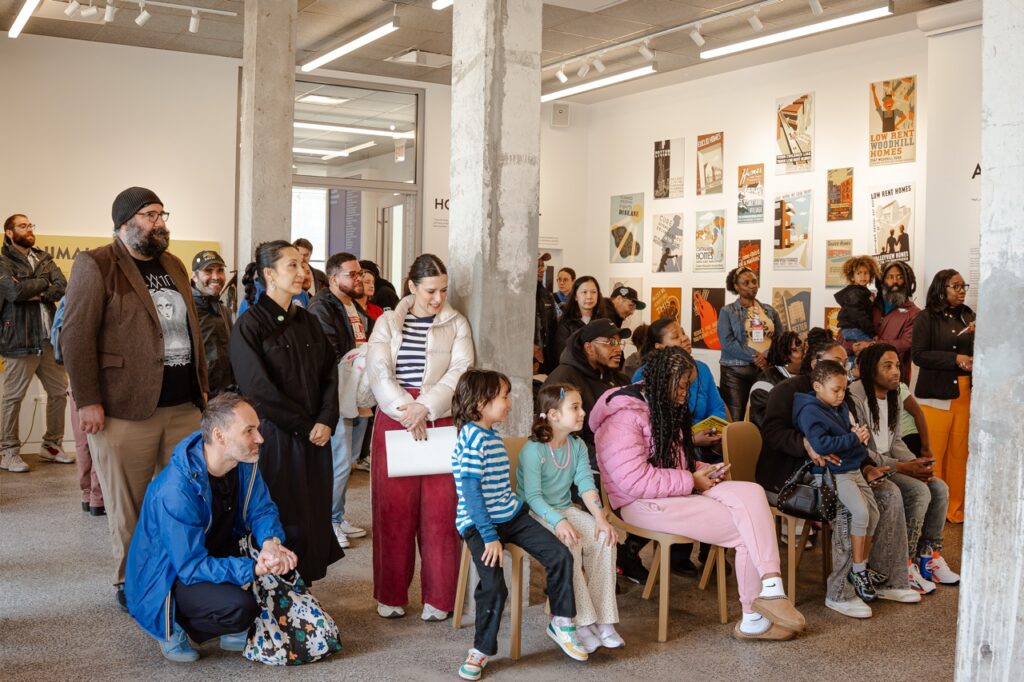All-ages crowd waiting for a performance at the National Public Housing Museum