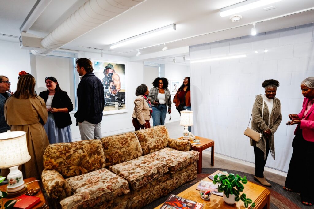 People socialize in an art gallery with a vintage living room