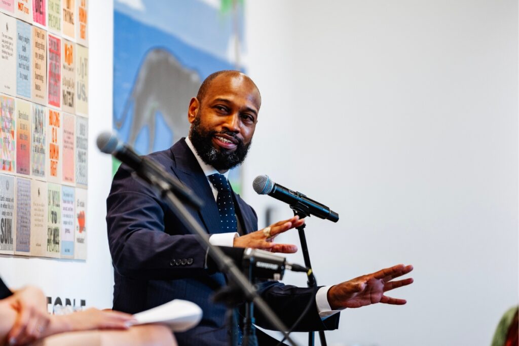 Artist Nathaniel Mary Quinn speaking into a microphone