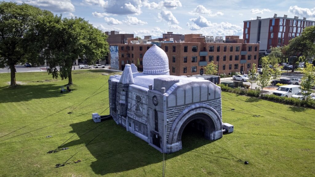 A white inflatable building installed next to the National Public Housing Museum
