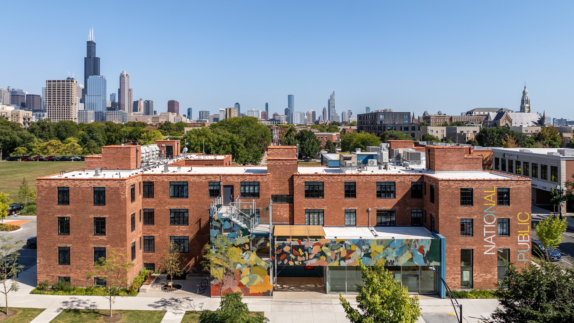 View of the 3-story National Public Housing Museum with the Chicago skyline in the background
