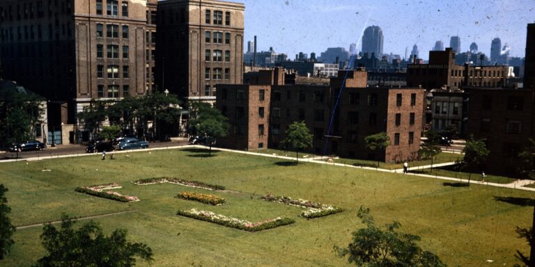 Dusty scan of a vintage photograph showing green space surrounding a public housing complex