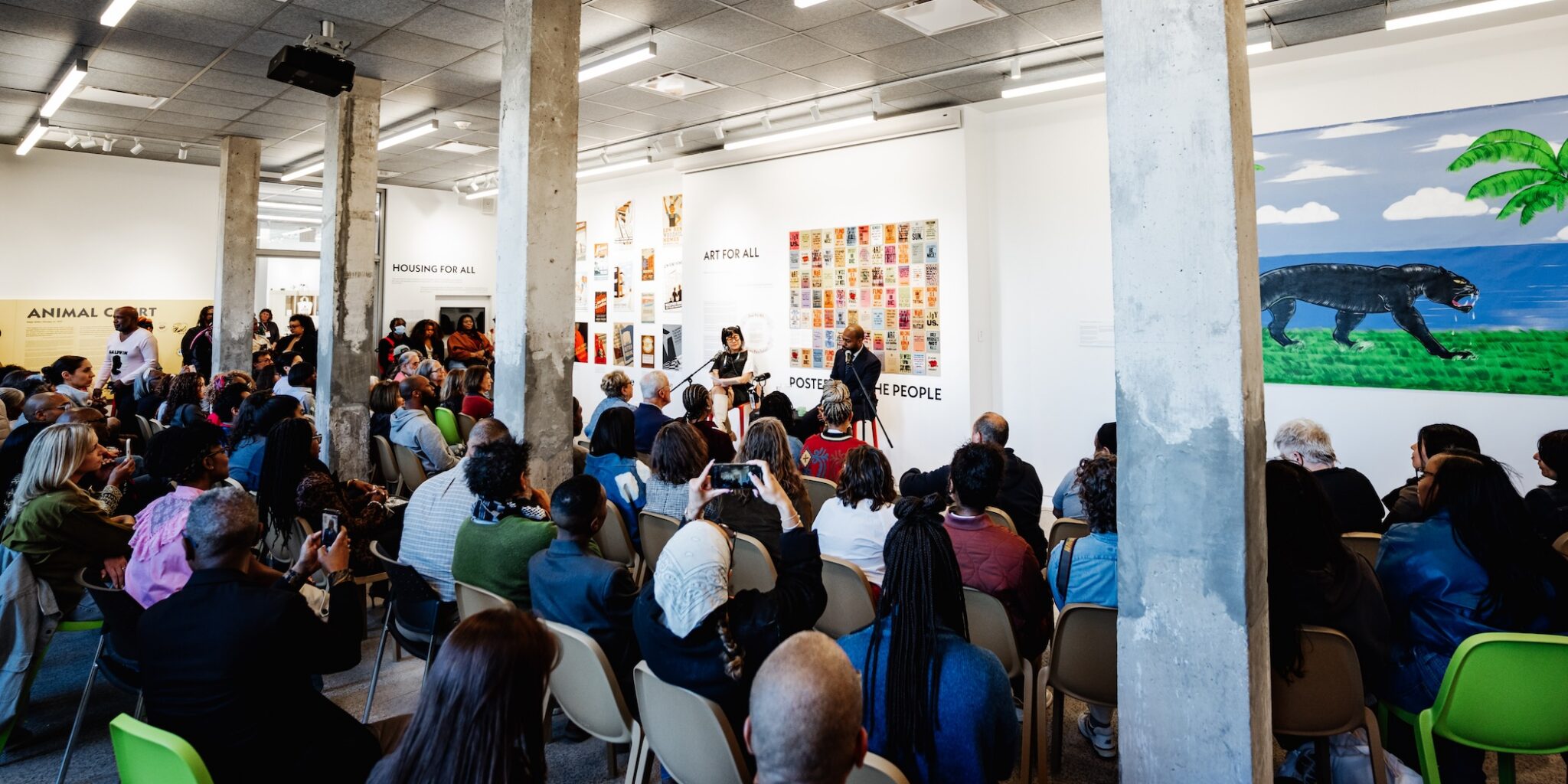 An artist talk in front of a large audience in the Living Room