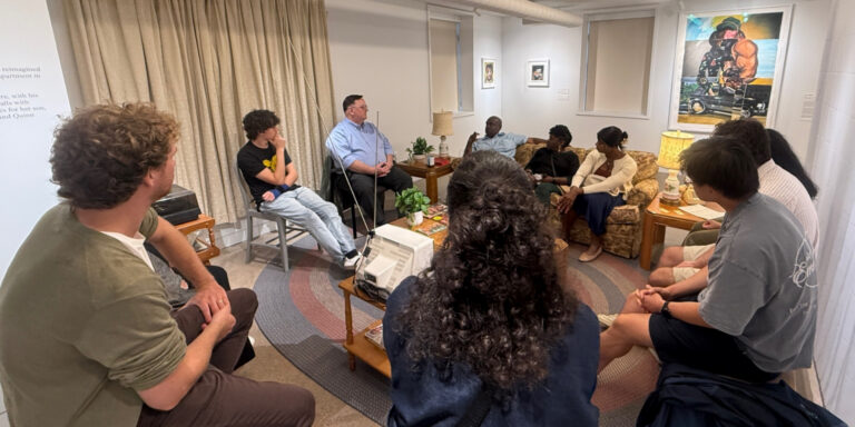 A diverse group of people gather in a circle to have a discussion